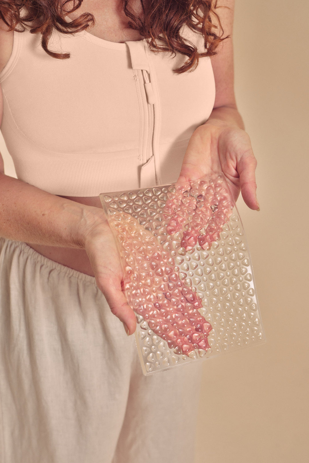Person holding a clear lymph flow pressure pad 
