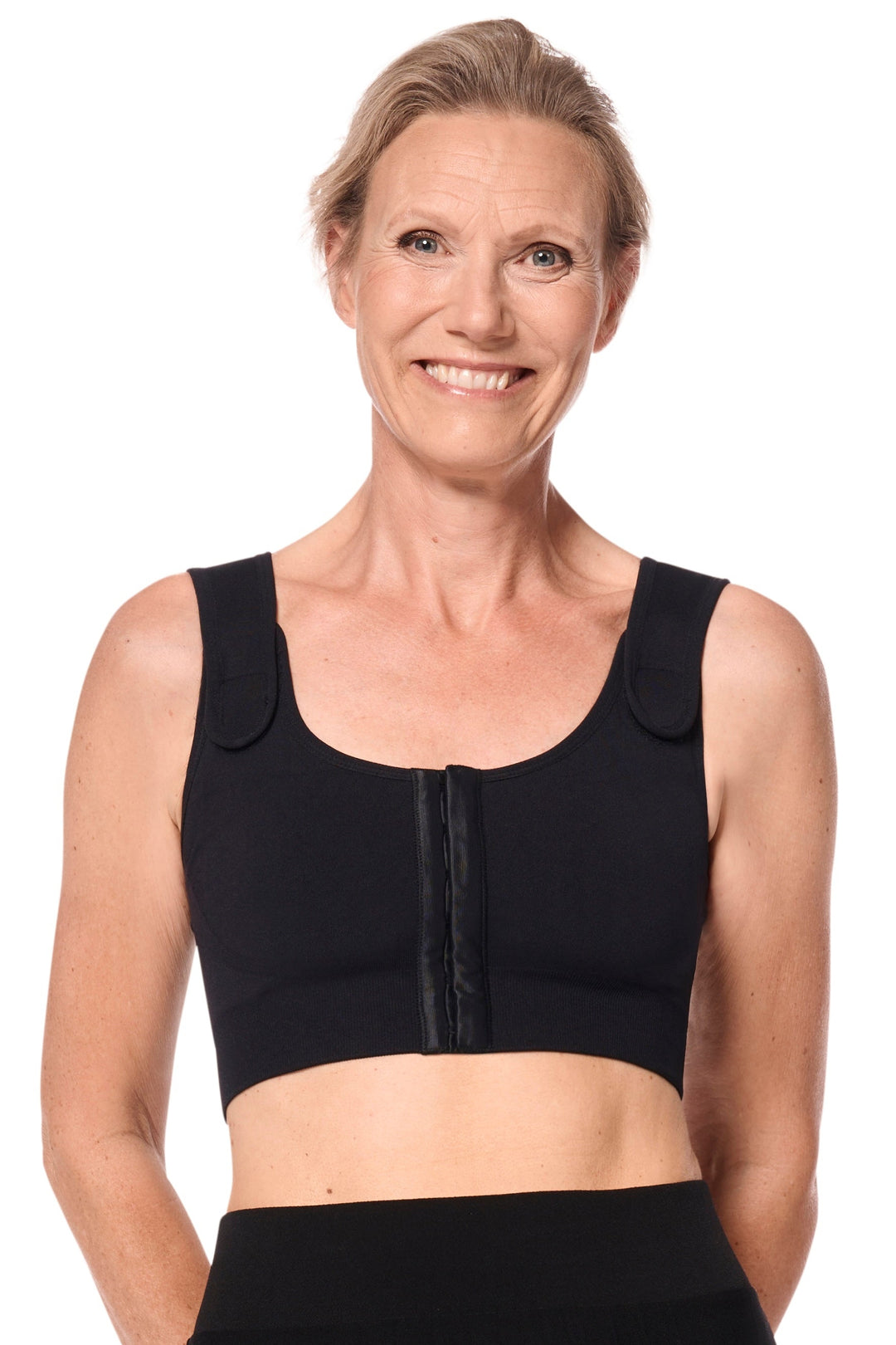Woman wearing a black compression bra on a white background