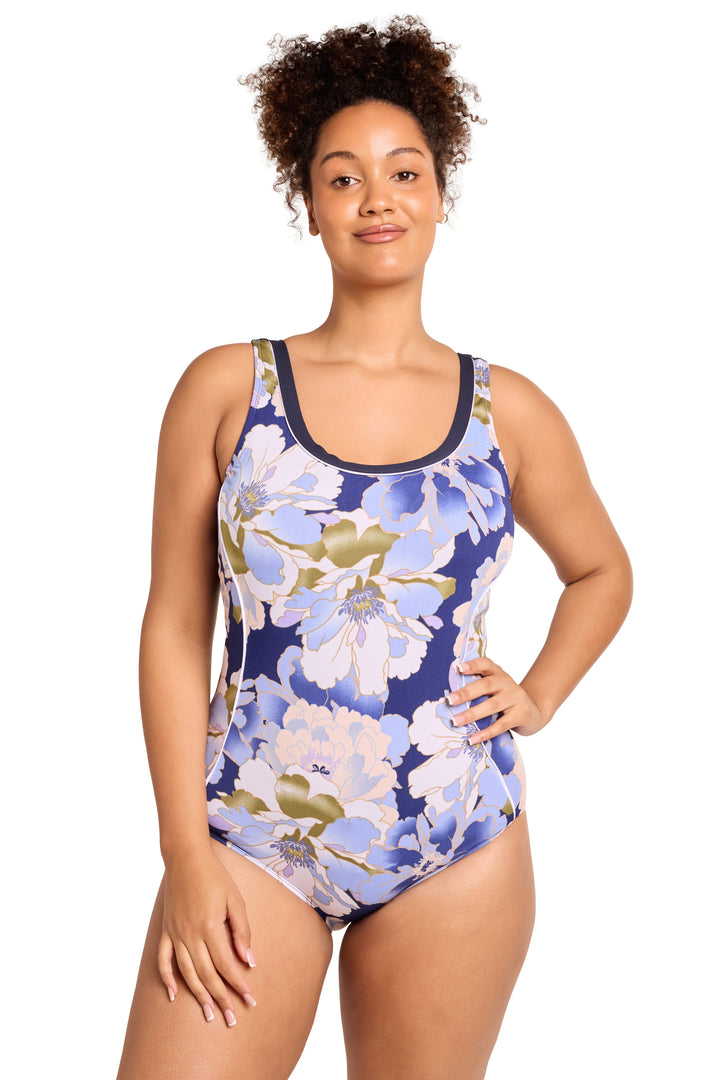 Woman wearing a blue floral one-piece swimsuit on a white background